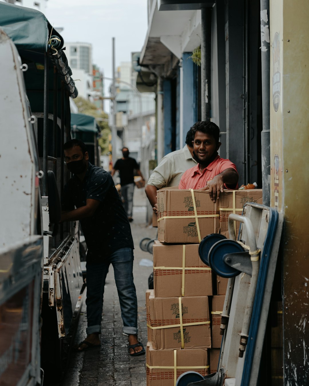 man-in-yellow-t-shirt-and-black-pants-standing-beside-brown-cardboard-boxes-yuu2h68ingi